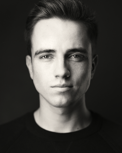 Portrait photo of white male with black background and clothing