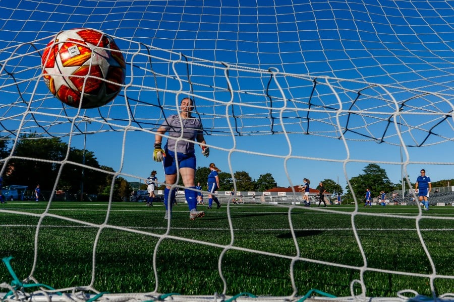 A photo of a football in the back of a net from a Womens football match, taken by Unsplash photographer My Profit Tutor